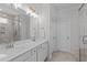 Modern bathroom features double sinks, quartz countertops, framed mirror, and a glass-enclosed shower for a luxurious experience at 3262 Ripley River Rd, New Hill, NC 27562