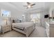 Bright bedroom with large windows, tray ceiling, fan, and neutral decor, creating a serene and inviting atmosphere at 3262 Ripley River Rd, New Hill, NC 27562