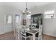 Dining area featuring a modern chandelier, dark wood table, and white chairs at 3262 Ripley River Rd, New Hill, NC 27562