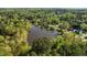 Aerial view of homes in a lush, green neighborhood surrounding a lake at 3417 Windmere Dr, Sanford, NC 27330