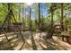 Backyard deck featuring a porch swing, rocking chair and built in seating, all in a serene wooded setting at 3417 Windmere Dr, Sanford, NC 27330