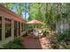 Tranquil backyard with a brick patio, dining set, and lush landscaping, perfect for entertaining at 3417 Windmere Dr, Sanford, NC 27330