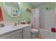 Charming bathroom with a floral shower curtain, decorative mirror, and ample natural light at 3417 Windmere Dr, Sanford, NC 27330