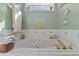 Relaxing bathtub with gold faucet and decorative tiled backsplash at 3417 Windmere Dr, Sanford, NC 27330