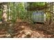 Quaint backyard storage shed with charming details amidst a leafy landscape at 3417 Windmere Dr, Sanford, NC 27330