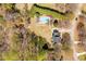Overhead aerial shot of property featuring a home, long driveway, pool, pool house, shed, trees, and manicured lawn at 3908 Yateswood Ct, Raleigh, NC 27603