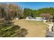 Spacious backyard with a white fence surrounding the inground pool, pool house, playground, and manicured lawn at 3908 Yateswood Ct, Raleigh, NC 27603