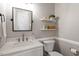 Cozy bathroom features a marble countertop, framed mirror and decoratively designed floating shelves at 3908 Yateswood Ct, Raleigh, NC 27603