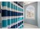 Bathroom with shower behind blue striped curtain and arced window at 3908 Yateswood Ct, Raleigh, NC 27603