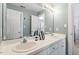 Bathroom with double sinks, a large mirror, vanity with white cabinets, and neutral-toned walls at 3908 Yateswood Ct, Raleigh, NC 27603