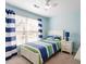 Bedroom showcasing a bed and window, with blue striped curtains, side table with drawers, and lamp at 3908 Yateswood Ct, Raleigh, NC 27603