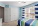 Bedroom features a bed, striped curtains, closet with double doors, and neutral-colored carpet at 3908 Yateswood Ct, Raleigh, NC 27603