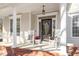 Inviting front porch with rocking chairs, swing, and decorative door at 3908 Yateswood Ct, Raleigh, NC 27603