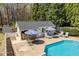 View of the inground pool and poolhouse with outdoor bar, seating, lounge chairs, and umbrellas at 3908 Yateswood Ct, Raleigh, NC 27603