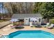 View of the inground pool and poolhouse with outdoor bar, seating, lounge chairs, and umbrellas at 3908 Yateswood Ct, Raleigh, NC 27603
