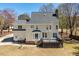 Rear exterior of the two-story home featuring a chimney, expansive windows, and a backyard deck at 3908 Yateswood Ct, Raleigh, NC 27603