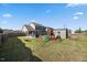 Spacious backyard with playset, fire pit area, patio, storage shed, and partial fence at 405 Club Center Dr, Youngsville, NC 27596