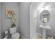 Well-lit half bathroom with modern fixtures, pedestal sink and decorative accents, creating a stylish space at 405 Club Center Dr, Youngsville, NC 27596