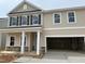 Two-story home featuring a beige siding, white trim, black shutters, and a two-car garage at 4105 Shadbush St, Raleigh, NC 27616