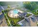 An aerial view of community pool and playground nestled in lush greenery for fun and relaxation at 425 Summit Trail Dr, Hillsborough, NC 27278