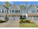 Charming townhome featuring stone accents, a two-car garage, and manicured landscaping at 425 Summit Trail Dr, Hillsborough, NC 27278