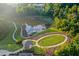 Aerial view of the community park featuring a pond, gazebo, walking paths, and open green space at 425 Summit Trail Dr, Hillsborough, NC 27278