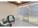 Cozy screened porch with wicker furniture, cushions, ceiling fan, and a door leading to the outside at 425 Summit Trail Dr, Hillsborough, NC 27278