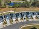 Aerial shot showcases modern houses with front-facing garages and well-kept yards along tree-lined streets near a pond at 4905 Abundance Ave, Raleigh, NC 27616