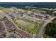 Aerial view of residential area featuring a pond and community center near modern apartments and townhomes at 4905 Abundance Ave, Raleigh, NC 27616