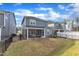Backyard of the home with a screened-in patio, lawn, and black metal fencing at 4905 Abundance Ave, Raleigh, NC 27616