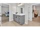 A bathroom with a grey vanity with modern hardware is situated between the bedroom and walk-in closet at 4905 Abundance Ave, Raleigh, NC 27616