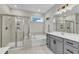 Bright bathroom features a shower, soaking tub, and a grey vanity with double sinks and bright lighting at 4905 Abundance Ave, Raleigh, NC 27616