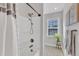 A tub and shower featuring a hand shower, storage caddy, window, and plant decor at 4905 Abundance Ave, Raleigh, NC 27616