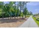 An outdoor fitness area with equipment for body weight exercises along a path surrounded by trees in the park at 4905 Abundance Ave, Raleigh, NC 27616