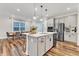 Well-equipped kitchen with island seating opens to the dining area and features modern stainless appliances at 4905 Abundance Ave, Raleigh, NC 27616