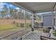 A screened-in patio features stylish furniture and provides views of the yard and surrounding greenery at 4905 Abundance Ave, Raleigh, NC 27616