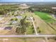 Aerial view of a traditional home with mature trees, a long driveway, a large lawn, and lush green surroundings at 495 Evans Rd, Princeton, NC 27569