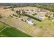 Aerial view of a traditional home and garage with a large, grassy lawn, and lush, mature greenery surroundings at 495 Evans Rd, Princeton, NC 27569