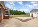 Manicured backyard featuring a patio, gravel beds, mature trees, and a detached garage at 495 Evans Rd, Princeton, NC 27569