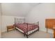 Comfortable bedroom with neutral carpet, pitched ceiling, iron bed frame and side table at 495 Evans Rd, Princeton, NC 27569