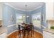 Bright breakfast nook with corner windows, hardwood floors, and a charming chandelier, ideal for morning meals at 495 Evans Rd, Princeton, NC 27569