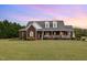 Inviting brick home showcasing a spacious front lawn and a welcoming porch, perfect for relaxing evenings at 495 Evans Rd, Princeton, NC 27569