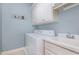 Functional laundry room with white washer, dryer, sink, and overhead storage at 495 Evans Rd, Princeton, NC 27569