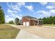 Wide exterior view of a brick home with a screened porch, detached garage, and manicured lawn at 495 Evans Rd, Princeton, NC 27569