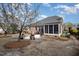 Landscaped backyard with a stone patio, a brick house and mature trees and greenery at 502 Sippihaw Oaks Dr, Fuquay Varina, NC 27526