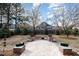 Spacious backyard featuring a stone patio, mature trees and manicured shrubbery and greenery at 502 Sippihaw Oaks Dr, Fuquay Varina, NC 27526
