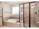 Bathroom features a glass enclosed shower, soaking tub with tile surround and window at 502 Sippihaw Oaks Dr, Fuquay Varina, NC 27526