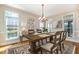 Elegant dining room with a large table, chandelier, artwork, and natural light from large windows, perfect for entertaining at 502 Sippihaw Oaks Dr, Fuquay Varina, NC 27526