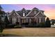 Stunning brick home boasts mature landscaping and a classic architectural design under a beautiful sunset sky at 502 Sippihaw Oaks Dr, Fuquay Varina, NC 27526