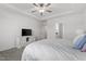 Large bedroom features a ceiling fan, tray ceiling, dresser, and ensuite bathroom at 517 Edenfield Dr, Fuquay Varina, NC 27526